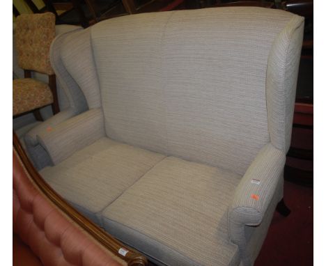 A contemporary wingback three piece suite, comprising double sofa and near-pair of armchairs 