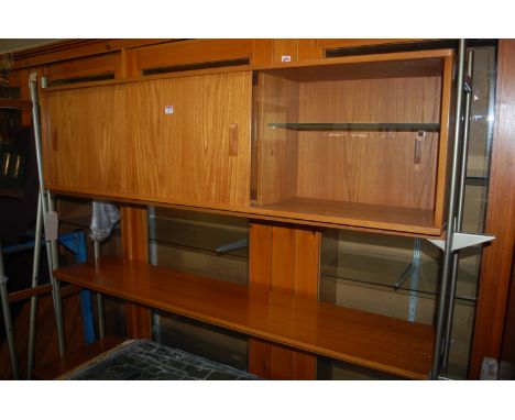 A 1970s teak and enamelled metal framed modular corner wall unit, having twin cupboard corner sections and further single she