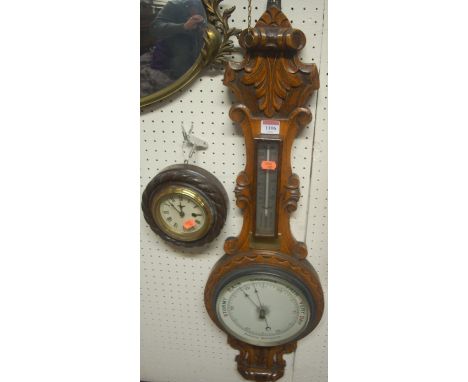 An early 20th century carved oak two dial aneroid wheel barometer; together with a small circular wall clock (2)