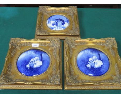 THREE GILT FRAMED BLUE AND WHITE CERAMIC PANELS DEPICTING CHILDREN 