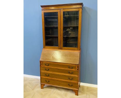 An Edwardian satinwood inlaid bureau bookcase with glazed doors to the top above a fall with interior drawers, above four gra