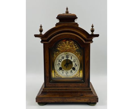 A late 19th century walnut cased arched door bracket clock with brass finials to the top, with 8 day German movement. Silvere
