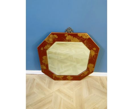 A contemporary Chinese red lacquered and gilt decorated wall mirror with a decorative brass hanging mount and a bevelled plat