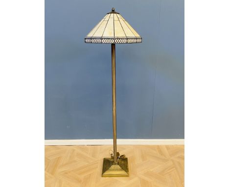 A contemporary Tiffany style standard lamp with a reeded column and a decorative base, with a typical design leaded light sha