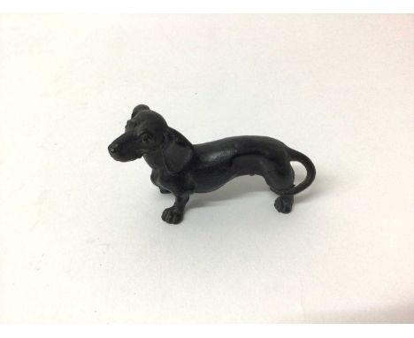Antique carved wooden model of a Dachshund with painted eyes and naturalistically carved body, 9cm long x 5cm high.