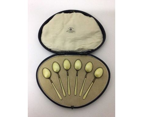 A cased set of six yellow-enamelled and silver-gilt teaspoons, Birmingham 1922The lid of the case is off (the hinge is broken