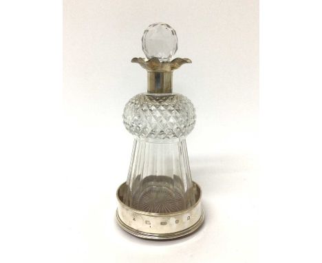 Silver mounted cut glass lidded thistle decanter, 25.5cm high, housed in a modern silver wine coaster

Some scratches and sma