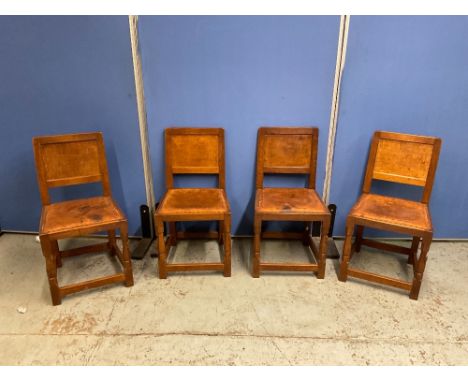 Robert Mouseman Thompson of Kilburn - a set of four oak dining chairs, with adzed panel backs, and brass nail leather upholst