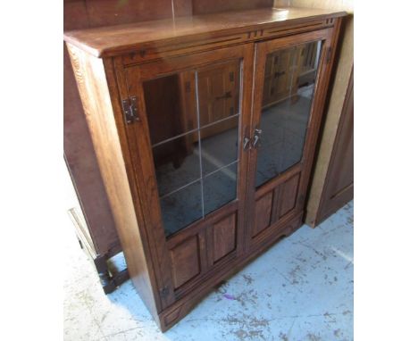 Reproduction oak bookcase with two part glazed panel doors and adjustable shelves on bracket feet, W92cm D29cm H112cm and a s