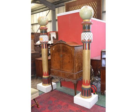 A pair of Masonic columns, world globe surmounting architectural statement pillars, decorated in Egyptian style with styalize