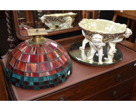 Ceramics and glass - a coloured glass pane ceiling lamp, lead lining; a decorative ceramics bowl, supported by three cherubs;