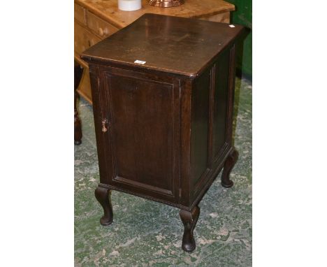 An early 20th century oak gramophone cabinet, converted into a storage cabinet, a single door enclosing storage with a single