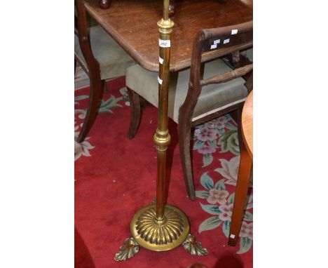 A 1930's brass standard lamp, lobed socle, circular base, three leaf form legs.