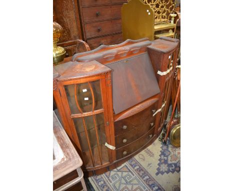 A 1940's side by side bureau, fall front enclosing leather writing surface and pigeon holes over three drawers, flanked by tw