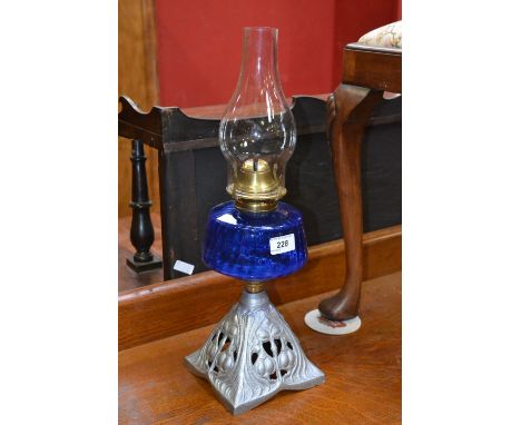 An early 20th century oil lamp, T Falks Burner, blue glass reservoir, cast base