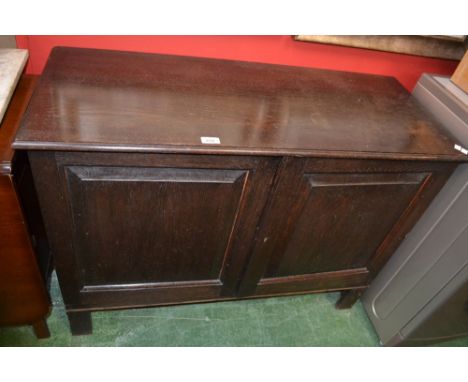 An oak side cupboard, moulded top, two fielded panel doors circa 1940