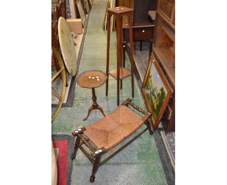 A raffia seated low stool with turned bar handles; a mahogany plant stand; a dropleaf tea trolley; a reproduction wine table,