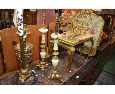 A gilt framed firescreen; an onyx and gilt metal nest of two tables; a gilt magazine rack; two onyx and gilt metal table lamp