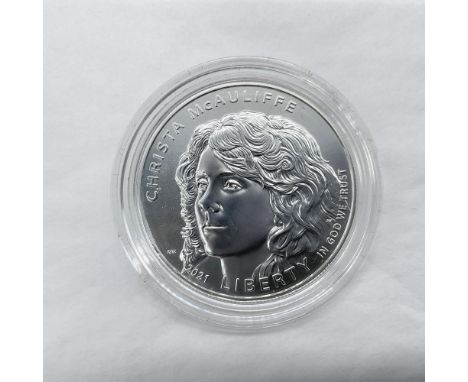 Philadelphia Mint. A Commemorative issued coin. The obverse side depicts Christa McAuliffe with a hopeful gaze. The reverse s