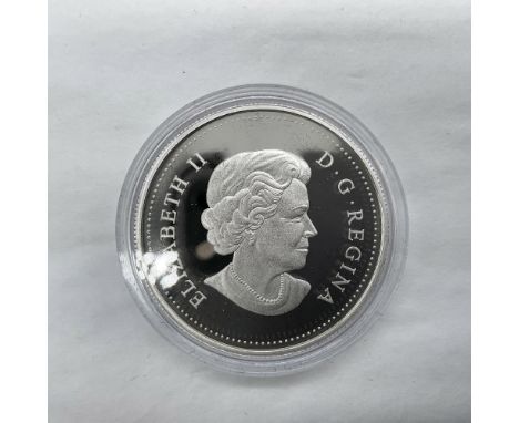 A 1 dollar Canadian coin. The obverse side depicts Queen Elizabeth II. The reverse side features Captain James Cook's arrival
