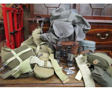 A selection of military issue equipment to include belts, webbing, water bottles, canvas bags, leather cased binoculars and a