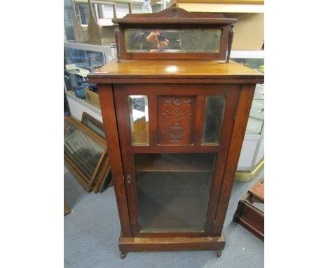 A Victorian walnut music cabinet with extended mirrored back supported on turned columns, above a partially glazed door with 