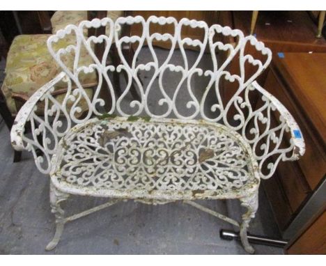 A weathered cast iron garden bench with scrolled ornament, on cabriole legs 