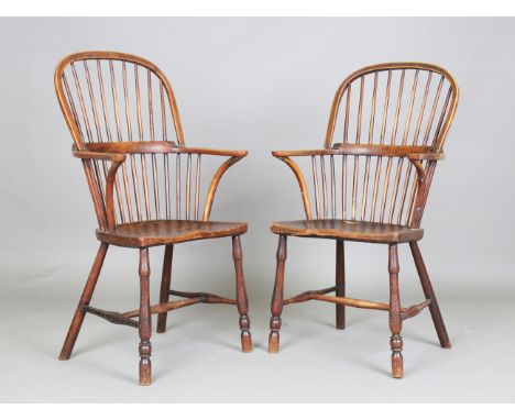 A pair of mid-19th century provincial ash, elm and fruitwood stick back Windsor armchairs with flattened handrests and shaped