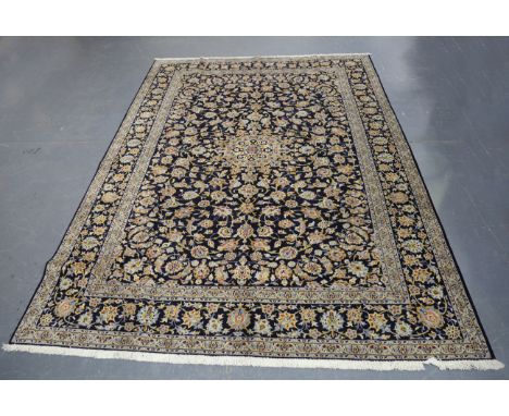 A Kashan carpet, Central Persia, late 20th century, the midnight blue field with a flowerhead medallion, within a palmette bo