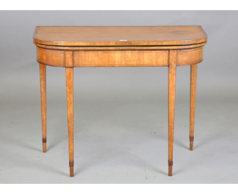 A George III satinwood fold-over card table, the hinged top and frieze crossbanded in tulipwood, on square tapering legs, hei