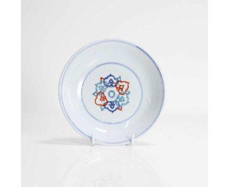 A Chinese doucai saucer, Kangxi (1662-1722), the centre painted with stylised lotus blooms, the underside with lingzhi sprays