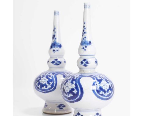 Two Chinese blue and white sprinkler vases, Kangxi (1662-1722), each in the form of a double gourd, painted with scrolling fl