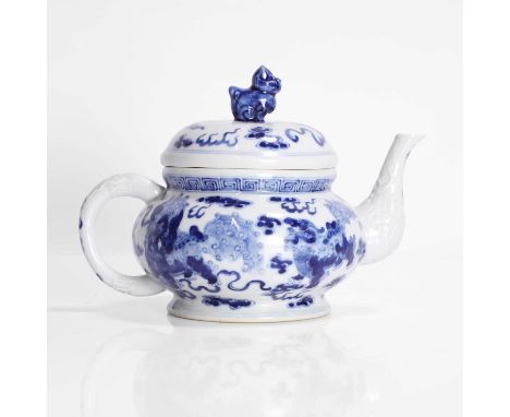 A Chinese blue and white teapot, Qing dynasty (1644-1911), painted with Buddhist lions playing with a brocade ball, the handl
