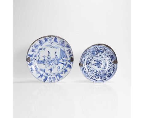 Two Chinese blue and white plates, Kangxi (1662-1722), each with rounded sides rising from a circular foot, mounted with a si