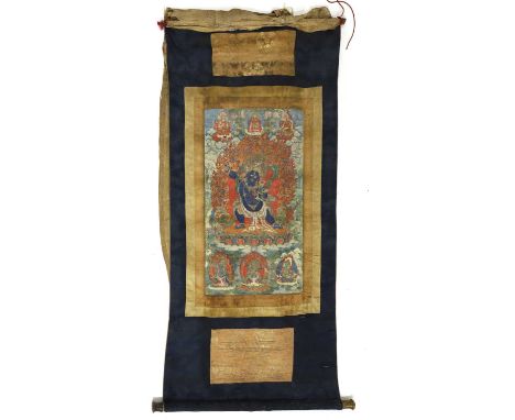 A Tibetan thangka, 18th century, painted with Mahakala wearing elaborate jewellery and a tiger skin lower garment, holding a 