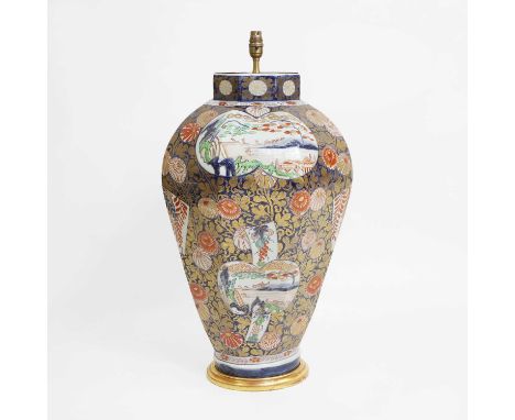 A large Japanese Imari vase, early 18th century, of tapering form, painted with landscapes or flowers in shaped panels, surro