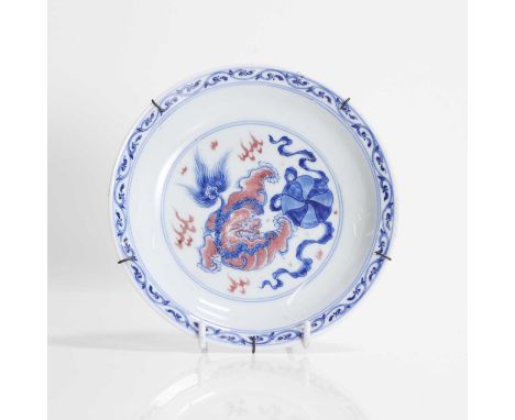 A Chinese copper-red and underglaze blue saucer, Qianlong (1736-1795), the rounded sides rising from a circular foot to a fla