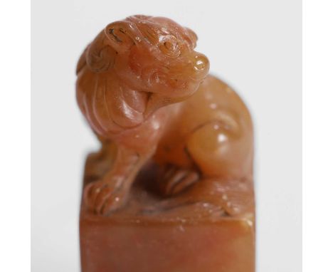 A Chinese soapstone seal, Republic period (1912-1949), the finial carved as a Buddhist lion seated on its haunches, the seal 
