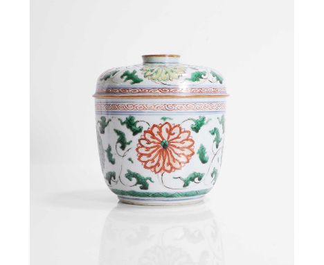 A Chinese wucai jar and cover, Kangxi (1662-1722), the rounded sides rising from a circular foot, painted with scrolling lotu