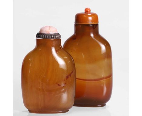 Two Chinese agate snuff bottles, Qing dynasty (1644-1911), plain,one with a coral stopper, carved with lingzhi and shou round