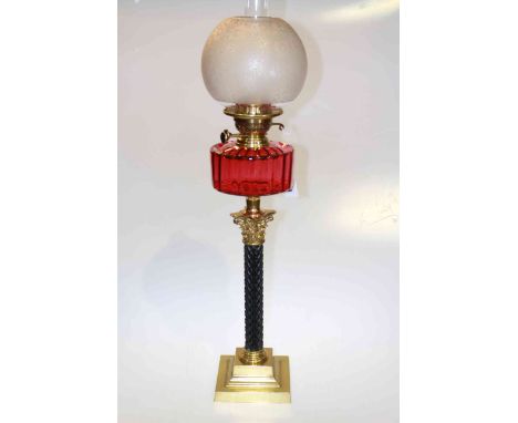 Brass and ebonised corinthian column oil lamp with ruby glass reservoir and frosted and etched glass shade