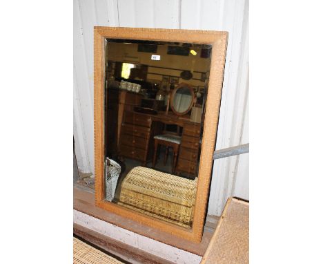 A bevel edged wall mirror with carved wooden surround