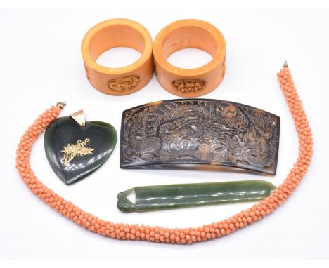 A yellow metal pendant set with a nephrite jade heart, nephrite jade bookmark, tortoiseshell buckle, coral necklace and two 1