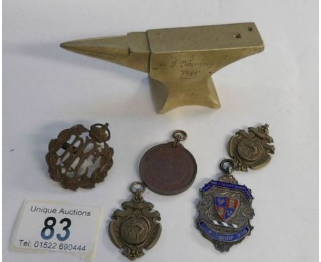 A silver and enamel 1908 fob, 4 other fobs, and RFC badge and a trench art brass anvil