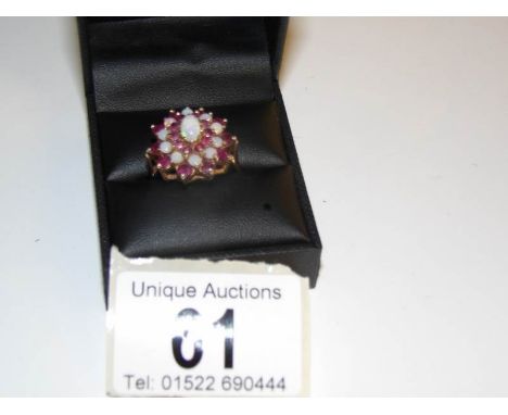 An opal and ruby cluster ring in gold, size R