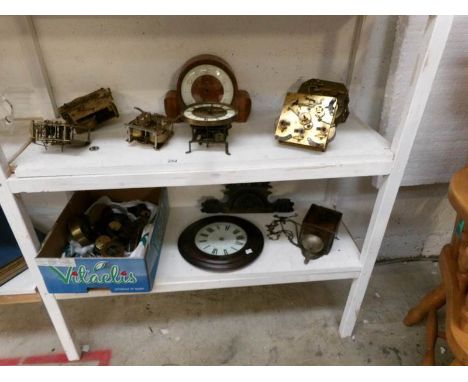 A good lot of clock movements, parts etc (2 shelves)