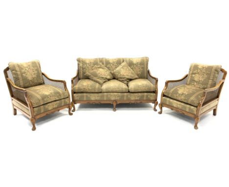 Early 20th century walnut and bergere lounge suite, comprising of a three seat sofa, with squab cushions and cabriole support