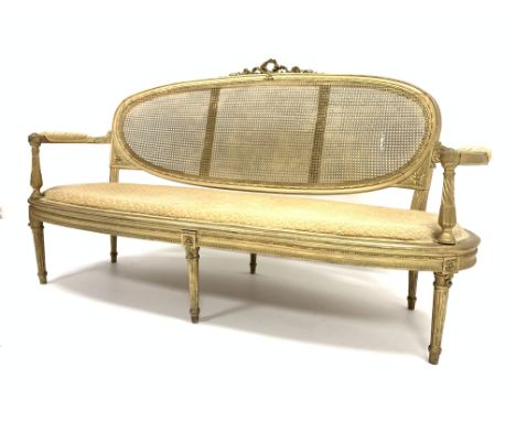 19th century French Louis XVI style gilt wood and bergere settee, applied ribbon and floral carved decoration, bowed arm rest