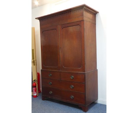 A large 18th century mahogany linen press: the cornice with Hepplewhite-style arcading above two plum pudding panelled doors 
