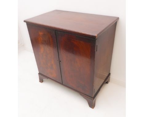 A reproduction mahogany two-door cabinet: moulded top above flame-mahogany and veneered front, raised on French-style bracket